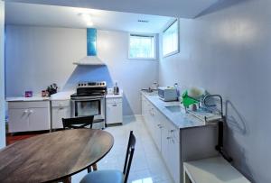 Bright Basement & Private Bathroom, free Parking في فوغان: مطبخ مع طاولة خشبية وطاولة طعام