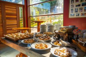 a buffet of bread and pastries on a table at Surya-Pan Hotel Refúgio in Campos do Jordão