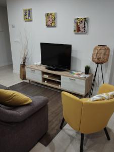 sala de estar con TV y 2 sillas en Alojamiento Buenos Aires en Ourense