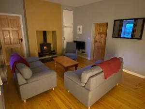 a living room with two couches and a fireplace at Carrickamore Cottage in Boyle