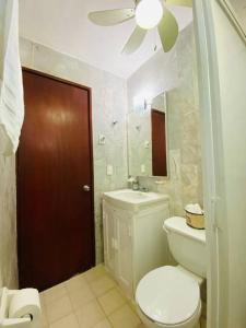 y baño con aseo, lavabo y espejo. en Zely Home #3, en Cancún