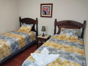 - une chambre avec deux lits et une lampe sur une table dans l'établissement Casa en Comayagua cerca de Palmerola, à Comayagua