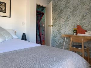 een slaapkamer met een bed, een bureau en een deur bij Yara Sobre Los Tejados de San Basilio in Córdoba