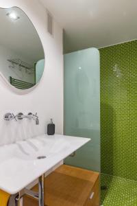 La salle de bains est pourvue d'un lavabo blanc et d'un miroir. dans l'établissement El Mirador de la Catedral de Oviedo, à Oviedo
