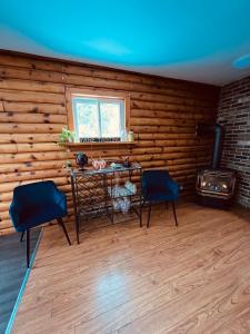 Habitación con mesa, 2 sillas y chimenea. en Casa Maria Irena en Meaford