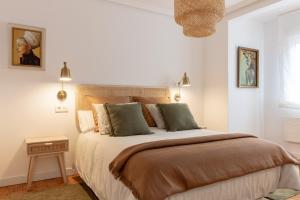 - une chambre blanche avec un grand lit et des oreillers verts dans l'établissement El Mirador de la Catedral de Oviedo, à Oviedo