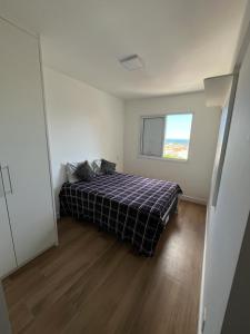 1 dormitorio con 1 cama en una habitación con ventana en Apartamento no Guarujá - Enseada, en Guarujá