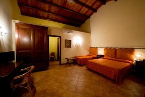 a hotel room with two beds and a tv at Baglio Cudia Resort in Marsala