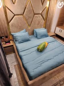 uma cama grande com lençóis azuis e uma almofada verde em City View Apartments em Lekki