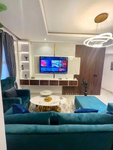 uma sala de estar com sofás azuis e uma televisão em City View Apartments em Lekki