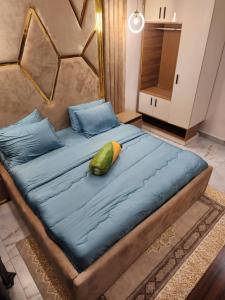 uma grande cama azul com uma almofada em cima em City View Apartments em Lekki