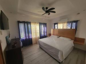 sypialnia z łóżkiem i wentylatorem sufitowym w obiekcie Villa Rita w mieście La Ceiba