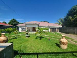 a house with two large vases in the yard at Villa Rita in La Ceiba