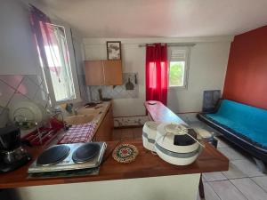 a room with a kitchen with a table and a couch at Villa yoyo poirier in Sainte-Anne