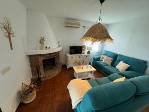 a living room with a blue couch and a fireplace at Villa en Frigiliana con piscina, jacuzzi y espectaculares vistas in Frigiliana