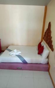 uma cama com um laço num quarto em lanta white sand beach guesthouse em Ban Mo Nae