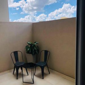 two chairs and a table on a balcony with a potted plant at Nuevo, acogedor y a un paso de todo!! CON COCHERA in Corrientes