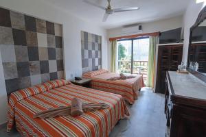 a hotel room with three beds and a window at Hotel y Villas Quinta Minas in Los Ayala