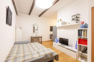 a bedroom with a bed and a tv and shelves at Molinari House Diamond - Appartamento Raffinato in centro Modena - Free ZTL in Modena