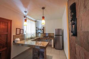 cocina con fregadero y nevera en Hotel y Villas Quinta Minas, en Los Ayala
