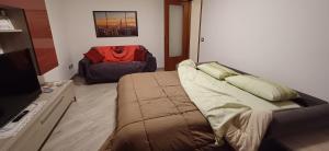 - une chambre avec un lit, un canapé et une chaise dans l'établissement Trilocale Arco d'Augusto con box, à Aoste