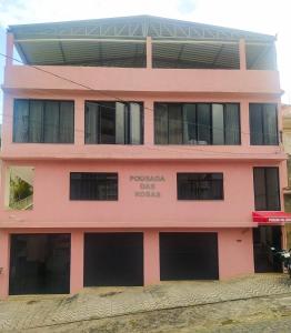 a pink building with the name of the hotel at Hotel Pousada das Rosas in São Lourenço