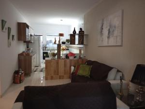 盖比姆Praia Guaibim的客厅里有一张沙发和一个厨房