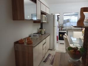 a kitchen with a refrigerator and a bowl of fruit on the counter at Praia Guaibim in Guaibim
