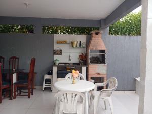 a patio with a table and chairs and a brick oven at Praia Guaibim in Guaibim