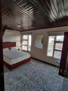 um quarto com uma cama e duas janelas em Hotel - La Perla Del Caribe em Ríohacha