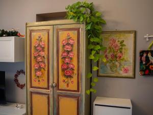 a wooden cabinet with flowers on it in a room at Apartament u Olechny in Bydgoszcz