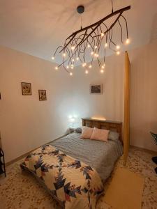 een slaapkamer met een bed en een kroonluchter bij Ciuri Ciuri Apartments in Casteldaccia