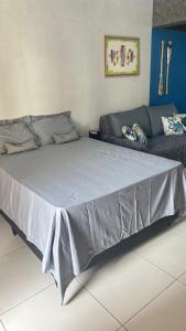 uma cama grande num quarto com um sofá em Maresia 7B em Salvador