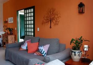 uma sala de estar com um sofá cinzento com almofadas coloridas em Casa de Praia Penha, Beto Carrero, 500m da Praia da Armação em Penha