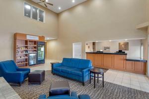 a waiting room with blue chairs and a counter at Comfort Suites Normal University area in Bloomington