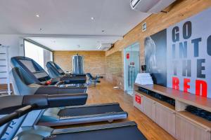 a gym with cardio machines and a wall with a poster at Radisson RED Campinas in Campinas