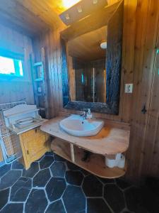 een houten badkamer met een wastafel en een spiegel bij Valen Cabins in Reine in Reine