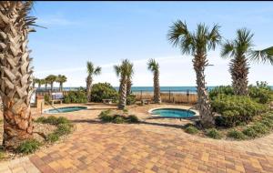 a resort with two pools and palm trees and the ocean at Two Bedroom Apartment at the Palace Resort in Myrtle Beach
