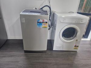 a dryer and a washing machine in a room at Mini Mansion in Auckland