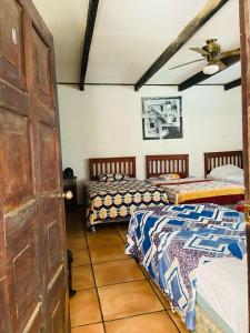 a room with three beds and a door at Old Bells Hostel in Santa Ana