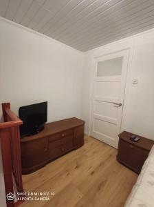 ein Schlafzimmer mit einem Bett und einem TV auf einer Kommode in der Unterkunft Studio/huis in Maastricht te huur in Maastricht