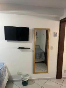 Pokój z lustrem i telewizorem na ścianie w obiekcie Flat La Piazzetta w mieście Pipa