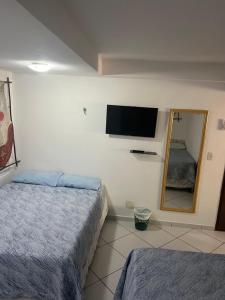 Habitación de hotel con 2 camas y espejo en Flat La Piazzetta, en Pipa