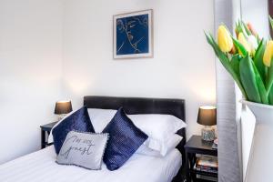 a bedroom with a bed with blue and white pillows at Entire House in Cambridge in Cambridge