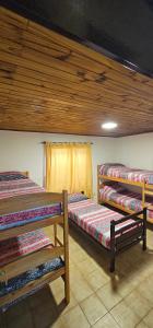 a room with three bunk beds and a window at Matices Hostel Centro in El Calafate