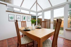 a conservatory dining room with a wooden table and chairs at Entire House in Cambridge in Cambridge