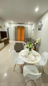 a living room with a table and white chairs at Serenity Condo in Piarco