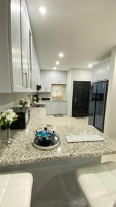 a kitchen with a granite counter top with a sink at Serenity Condo in Piarco