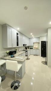 a kitchen with white cabinets and a black refrigerator at Serenity Condo in Piarco