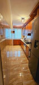 cocina con armarios de madera y nevera. en Apartment on the San River, en Przemyśl